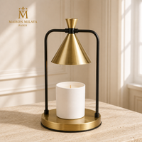Lampe chauffe-bougie conique dorée, structure noire et base ronde dorée, avec bougie éteinte